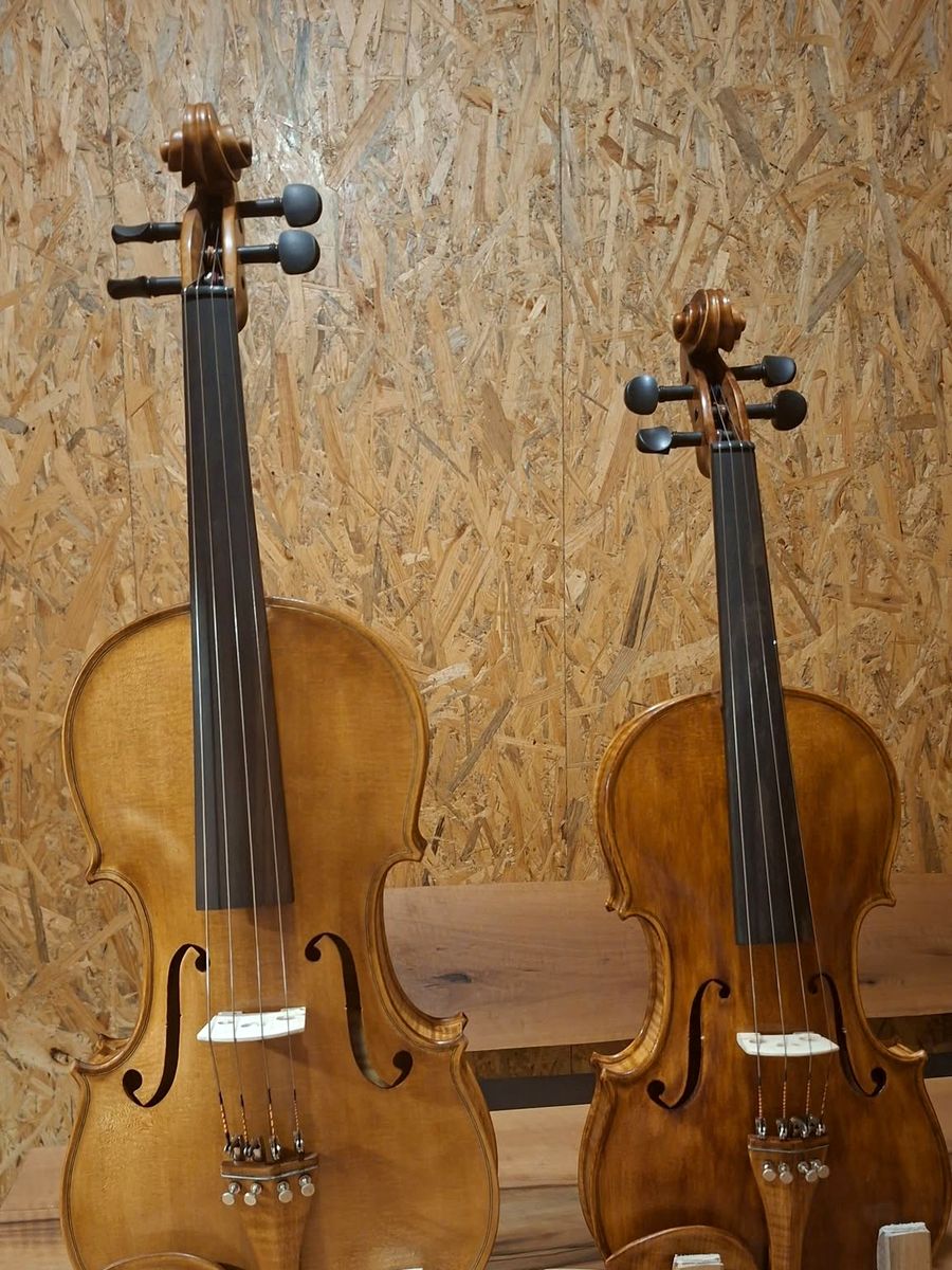Dvije violine na drvenim stalcima u radionici