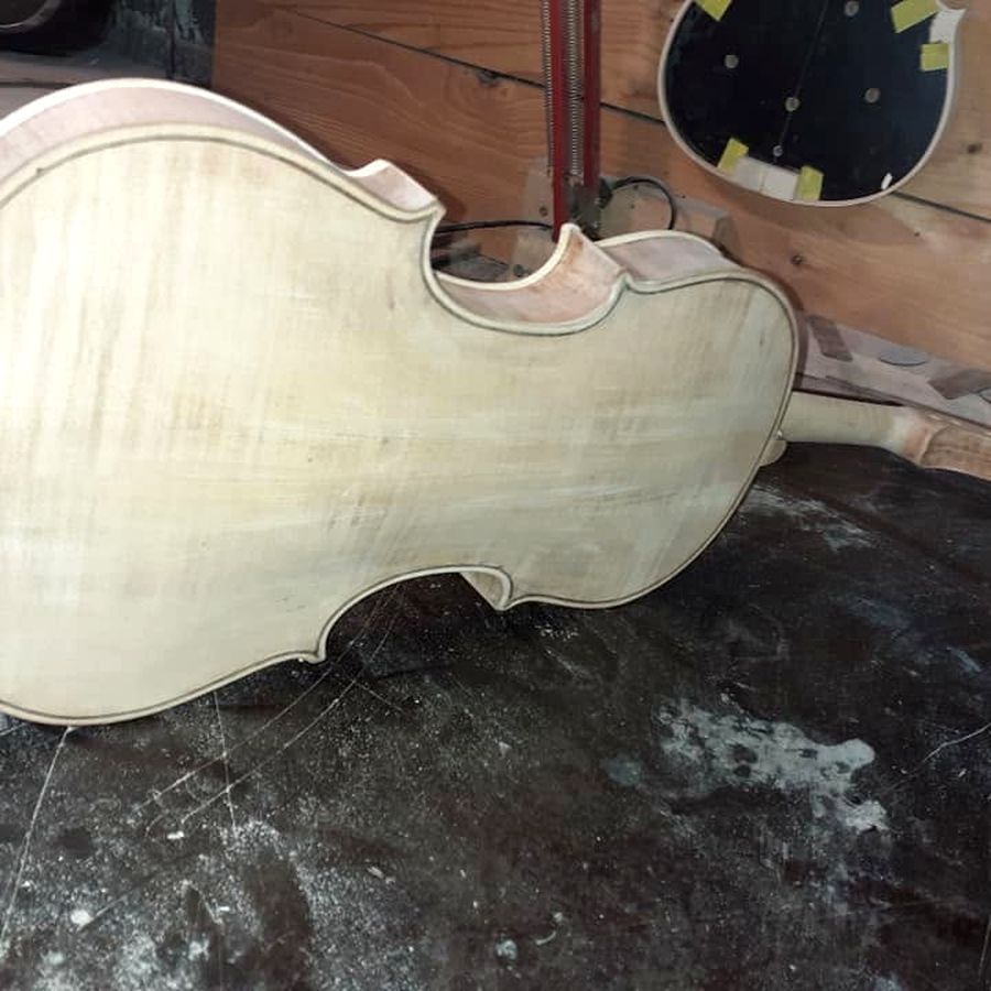 Izrada violine — nelakirano tijelo instrumenta na radnom stolu