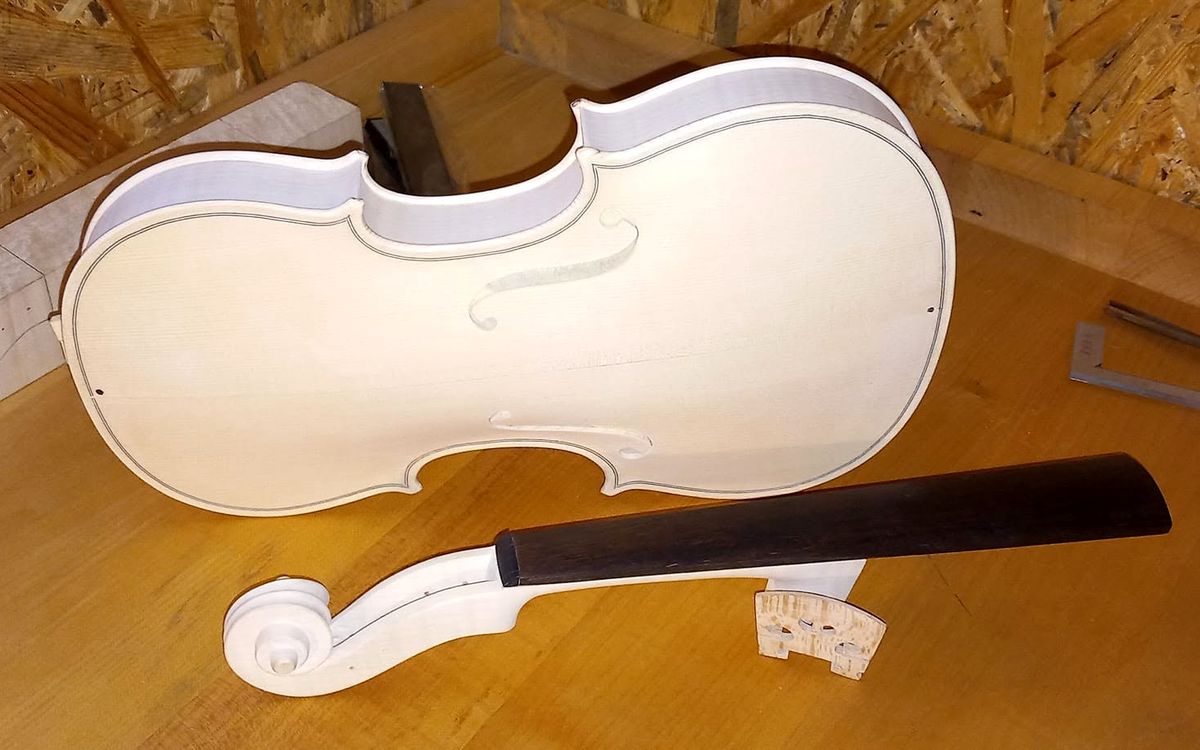 Nelakirana gornja ploča i vrat violine na radnom stolu