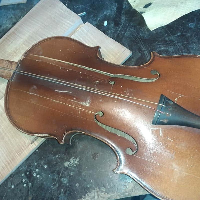 Gornja ploča stare violine prije restauracije — pukotine, ogrebotine i istrošen lak