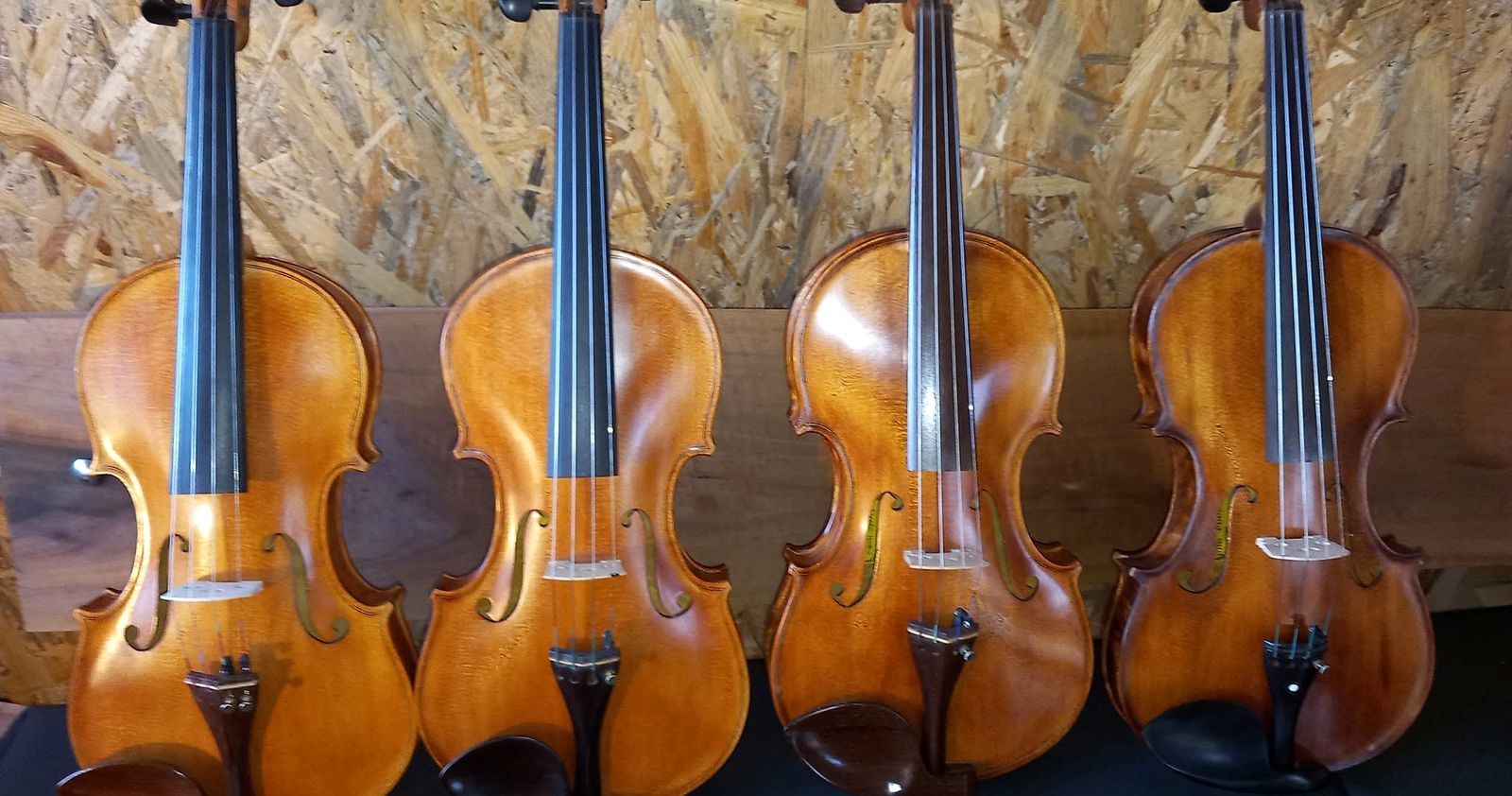 Četiri gotove violine poredane u radionici